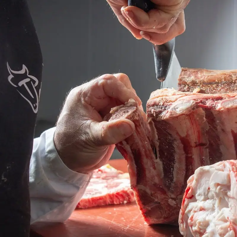 Deshuesado de un costillar de ternera en la sala de despiece